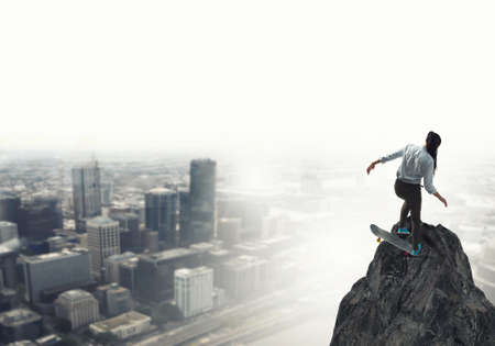 Active girl riding skateboard on rock top