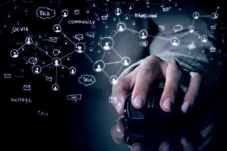 Hand of businesswoman on dark background using wireless computer mouse