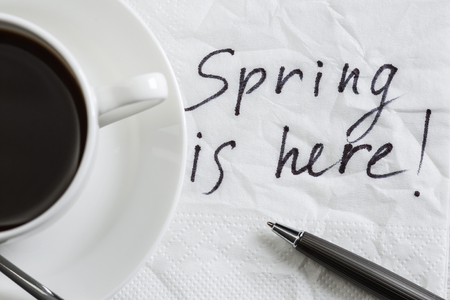 Spring is here message written on napkin and cup of coffee