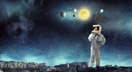 Young woman with carton box on head imagine she is astronaut