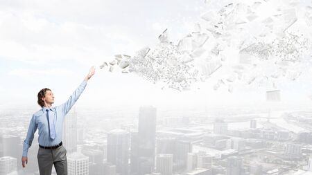 Young businessman throwing sheets of paper into the airの写真素材