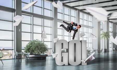 Youngh cheerful businessman dancing in office. Mixed mediaの写真素材