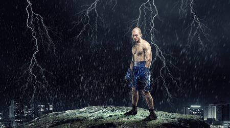 Strong boxer on dark background demonstrating power and enduranceの写真素材