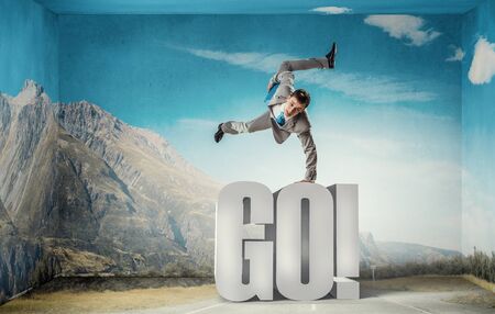 Active businessman making handstand on word go
