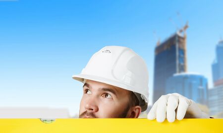 Engineer man in helmet outdoor using levelの写真素材