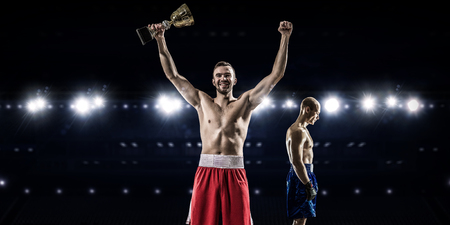 Two professional boxers fighting on arena in spotlightsの写真素材