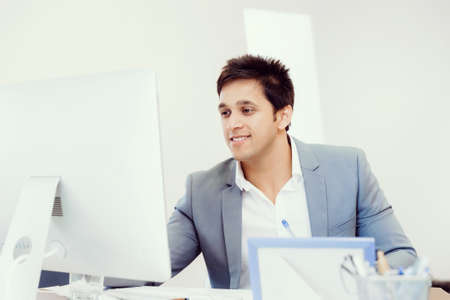 Businessman sitting in office working with computerの写真素材