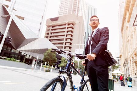 Young businessman wearing suit with bike outdoorsの写真素材