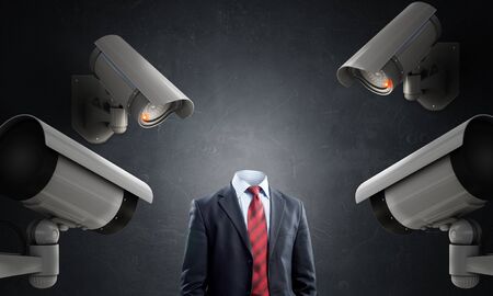 Unrecognizable businessman in room standing under security cameraの写真素材