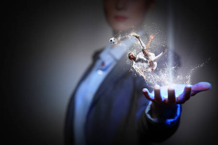 Close view of businesswoman holding in palm football game conceptの写真素材