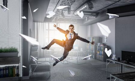 Funny jumping businessman in modern 3D rendering interior. Mixed mediaの写真素材