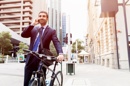 Young businessman wearing suit with bike outdoorsの写真素材