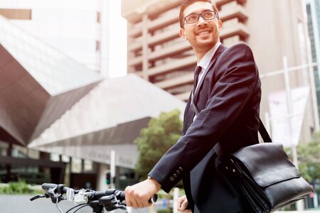 Young businessman wearing suit with bike outdoorsの写真素材