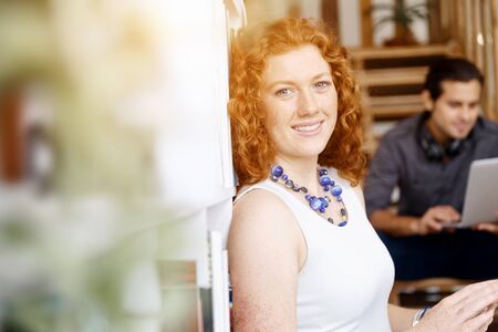 Portrait of two young people in casual clothes sitting at the stairs in office