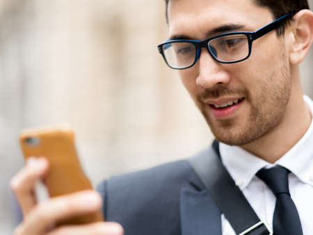 Portrait of young handsome businessman outdoor holding mobile phoneの写真素材