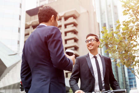 Two businessmen talking outdoors while taking coffee breakの写真素材