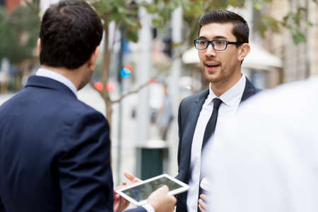 Two businessmen talking outdoors while taking coffee breakの写真素材