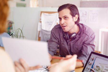Young woman in casual clothes in an office with draftsの写真素材