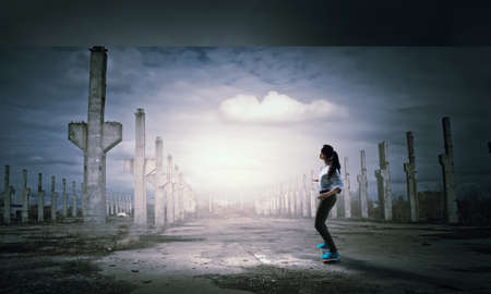 Teenager active girl riding skateboard on asphalt roadの写真素材