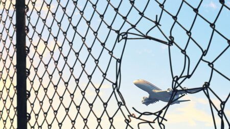 Airplane flying over blue sky at sunsetの写真素材