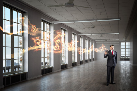 Senior businessman in office interior use tablet pc. Mixed mediaの写真素材