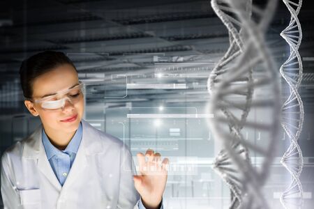 Woman scientist and 3D rendering DNA molecule image at media screenの写真素材