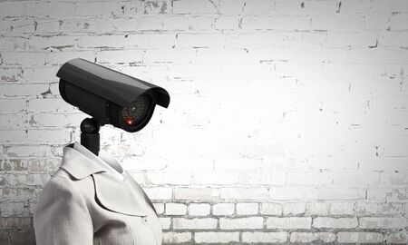 Woman in suit with security camera instead of headの写真素材
