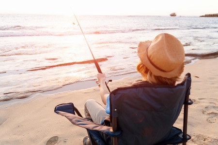 Teenage boy fishing with rod at seaの写真素材