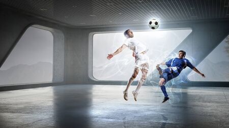 Office interior and football players fighting for ball . Mixed mediaの写真素材