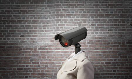 Woman in suit with security camera instead of headの写真素材