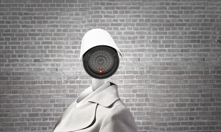 Woman in suit with security camera instead of headの写真素材