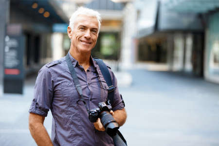 Senior man with camera in cityの写真素材