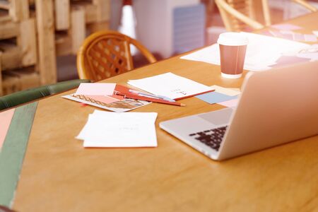 Desk with laptop and drafts and hands close upの写真素材