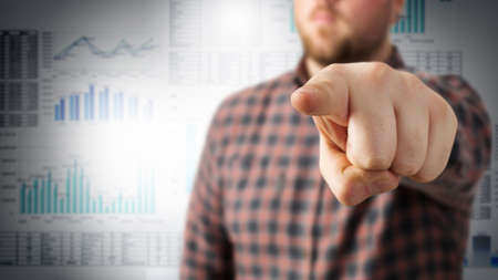 Young man in checked shirt showing his index finger towards cameraの写真素材