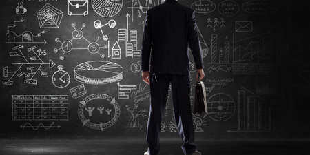 Bottom view of businessman and business ideas sketched at backgroundの写真素材