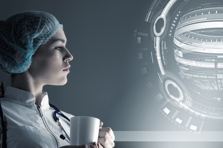 Young woman doctor looking thoughtfully at media screenの写真素材