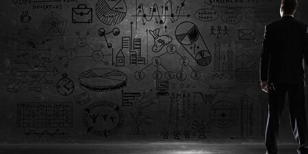 Bottom view of businessman and business ideas sketched at backgroundの写真素材