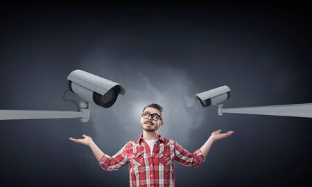 Young man in red checked shirt nder eye of cctv