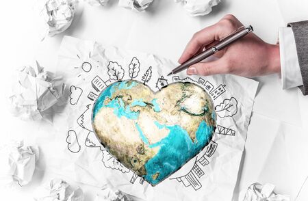 Hand of businesswoman drawing planet earth on paper. Elements of this image are furnished by NASAの写真素材