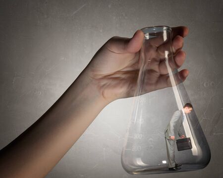 Young businessman with suitcase in glass tubeの写真素材
