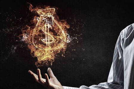 Dollar symbol in fire flames in male palmの写真素材