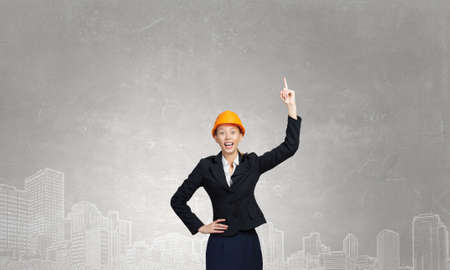 Woman builder in helmet point finger upの写真素材