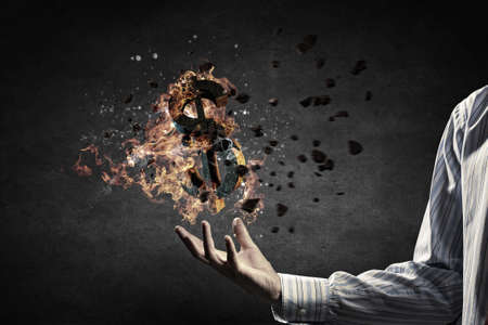 Dollar symbol in fire flames in male palmの写真素材