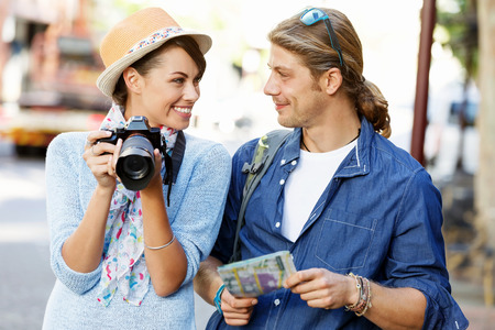 Smiling couple of tourists with the cameraの写真素材