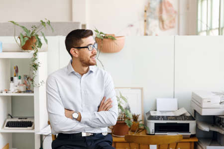 Young businessman standing in officeの写真素材