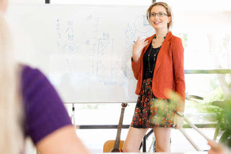 Casual businesswoman giving a presentation in the office to his colleaguesの写真素材