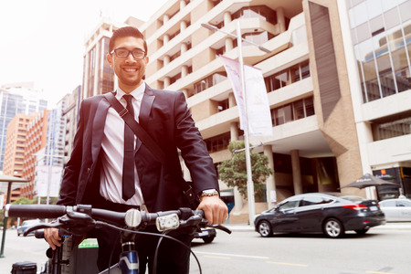 Young businessman wearing suit with bike outdoorsの写真素材