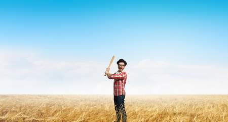 Young man in checked shirt with baseball batの写真素材