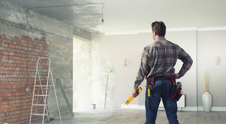 Builder man in checked shirt with tool belt on waist. Mixed mediaの写真素材