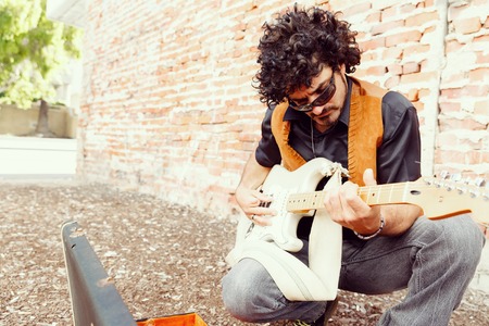 A street musician tuning his instrumentの写真素材